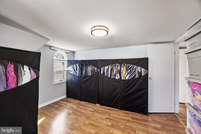 bedroom featuring wood finished floors and baseboards