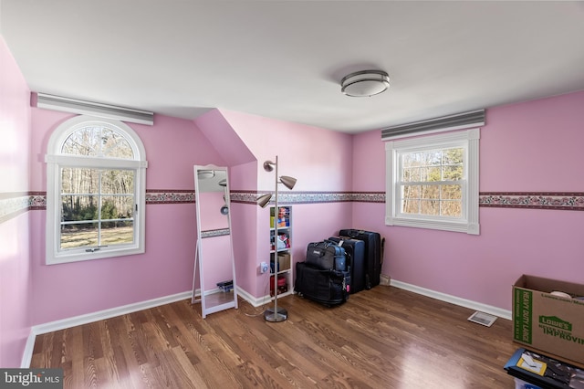 recreation room featuring wood finished floors, a healthy amount of sunlight, and baseboards