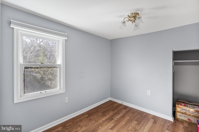 unfurnished bedroom featuring baseboards and dark wood-type flooring