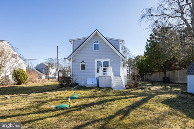 rear view of property with a yard and fence