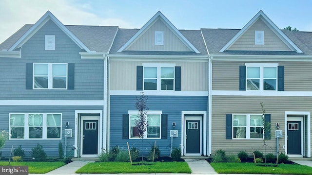 townhome / multi-family property with a shingled roof