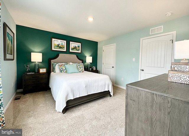 bedroom with light carpet, visible vents, and baseboards