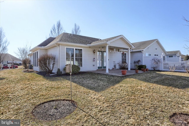 ranch-style house featuring a patio area, french doors, a front lawn, and fence