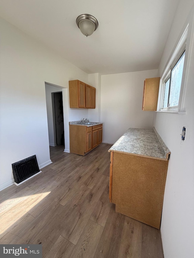 239 Midland, Brooklyn, MD 21225 - kitchen featuring light countertops, visible vents, baseboards, brown cabinets, and wood finished floors