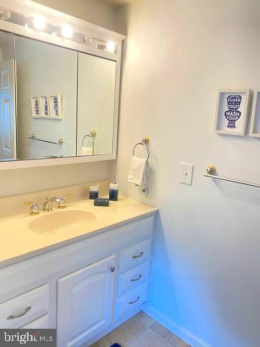 bathroom featuring vanity, baseboards, and tile patterned flooring