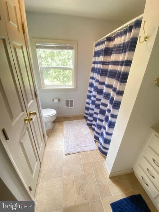 full bathroom featuring a shower with shower curtain, toilet, baseboards, and visible vents