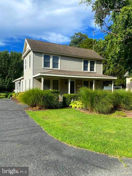 farmhouse-style home with a front lawn