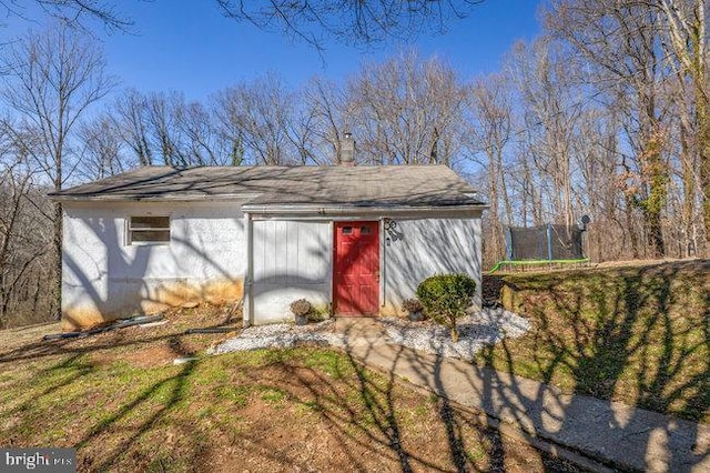 view of outbuilding with an outdoor structure and a trampoline