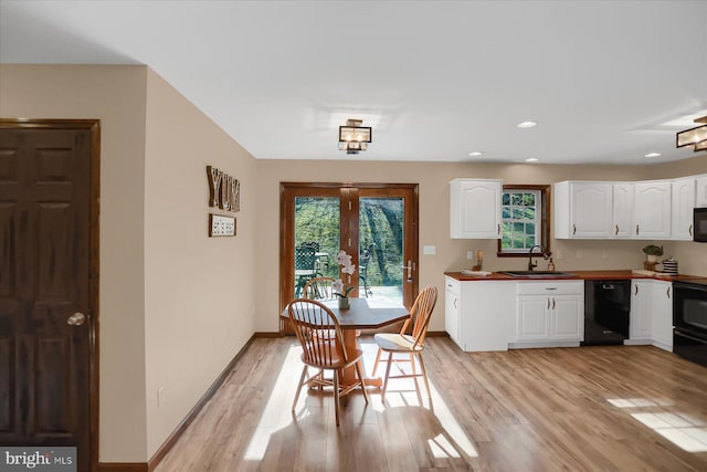 dining space featuring a healthy amount of sunlight, light wood-style flooring, and baseboards