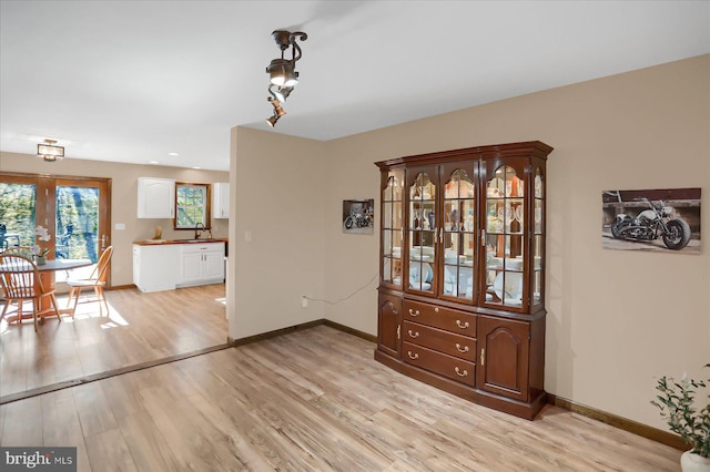 dining space with light wood-type flooring and baseboards