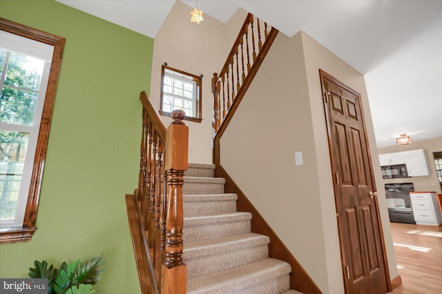 stairs featuring plenty of natural light and wood finished floors