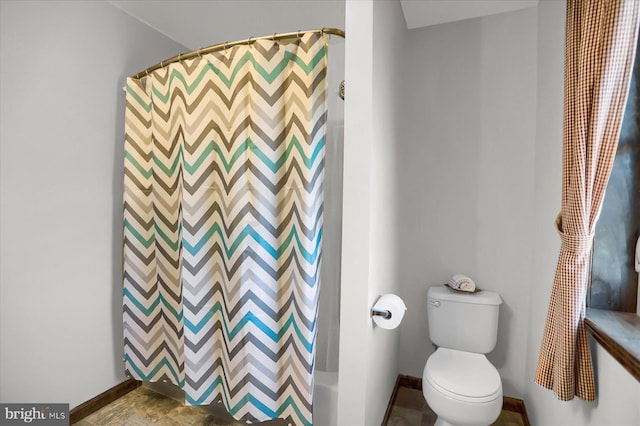 bathroom featuring curtained shower, baseboards, and toilet