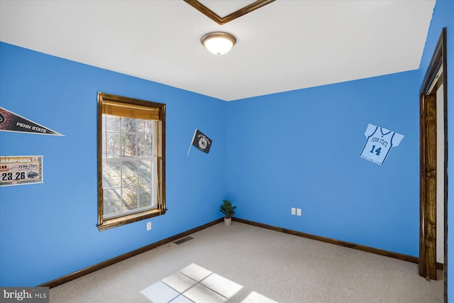 empty room with carpet flooring, visible vents, and baseboards