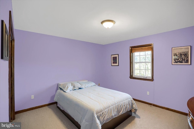 bedroom featuring light carpet and baseboards