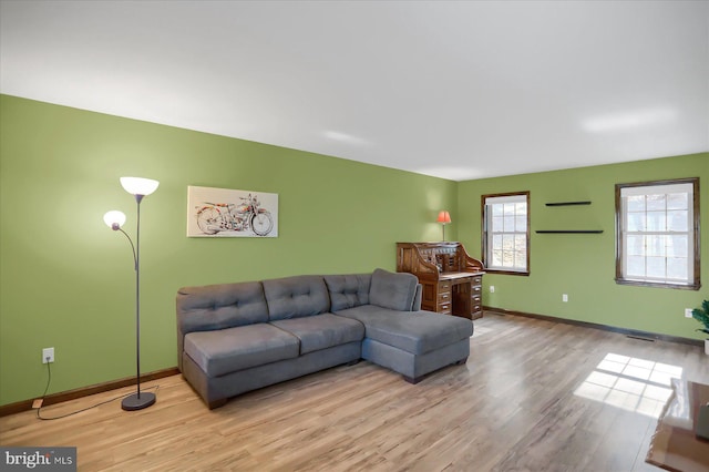 living area featuring visible vents, baseboards, and wood finished floors