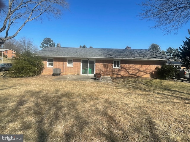 back of house with brick siding, cooling unit, a patio area, and a yard