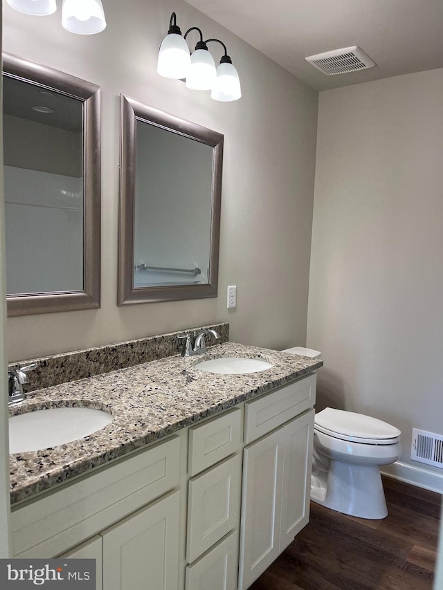 full bathroom featuring a sink, visible vents, toilet, and wood finished floors