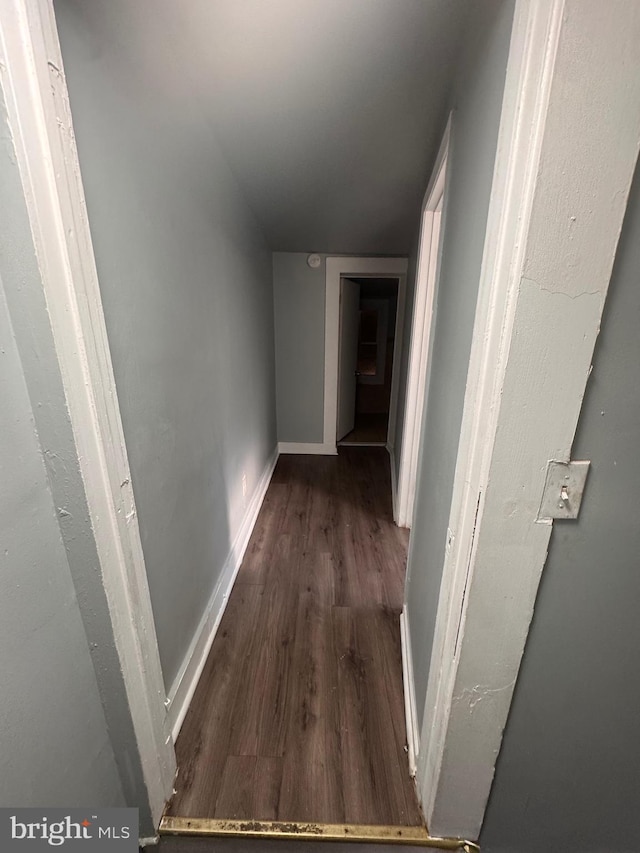 hall with dark wood-style floors and baseboards