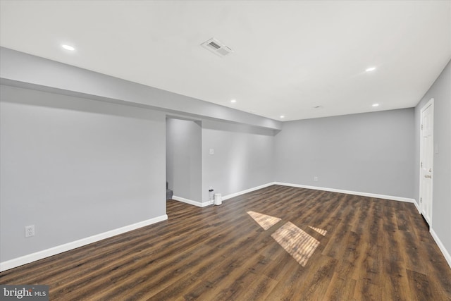 finished below grade area with dark wood finished floors, visible vents, recessed lighting, and baseboards