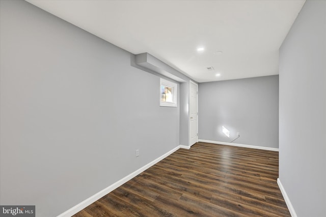 basement featuring dark wood finished floors and baseboards