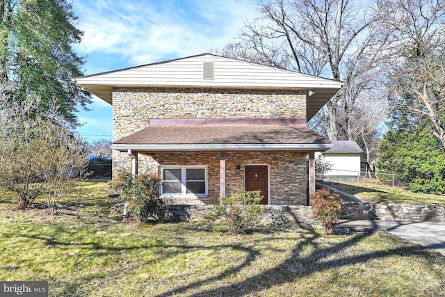 view of front of house with a front lawn, fence, and stone siding