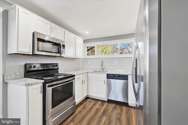 kitchen featuring a sink, white cabinets, light stone countertops, and stainless steel appliances