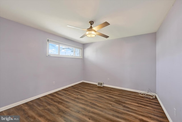 empty room with visible vents, baseboards, dark wood-type flooring, and a ceiling fan