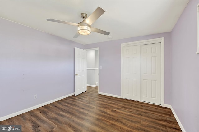 unfurnished bedroom with dark wood-style floors, a closet, baseboards, and a ceiling fan