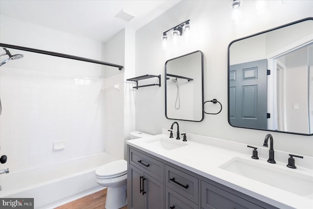 bathroom with shower / bath combination, toilet, visible vents, and a sink