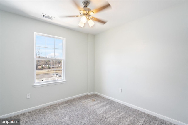 carpeted empty room featuring visible vents, baseboards, and a ceiling fan