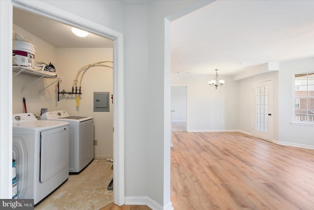 laundry area with light wood finished floors, baseboards, electric panel, laundry area, and independent washer and dryer