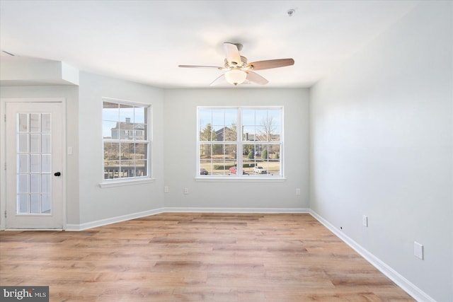 unfurnished room featuring a wealth of natural light, a ceiling fan, and baseboards