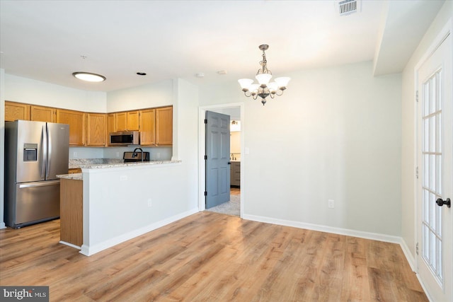 kitchen with visible vents, brown cabinets, appliances with stainless steel finishes, and light wood-style floors