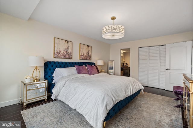 bedroom with a closet, baseboards, and dark wood-type flooring