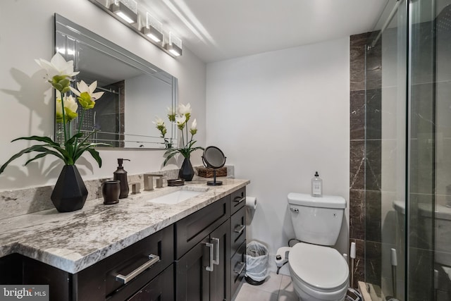 bathroom featuring toilet, a stall shower, vanity, and tile patterned flooring