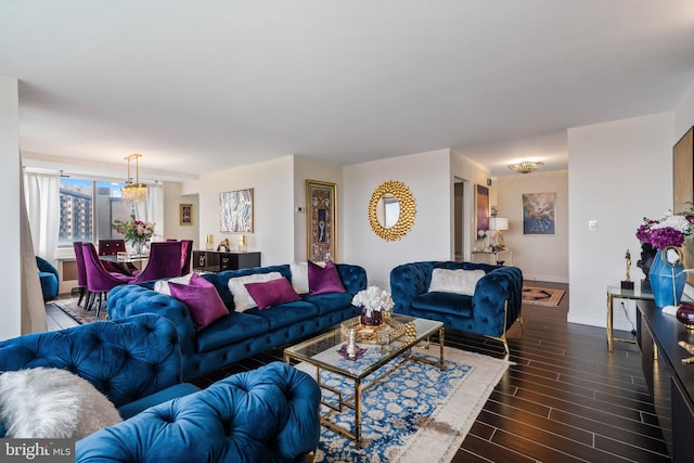 living room with wood finish floors, baseboards, and a notable chandelier