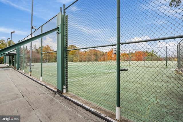 view of sport court with a gate and fence