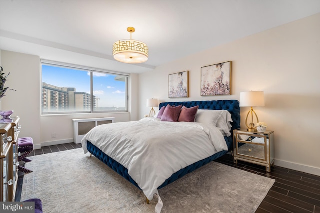 bedroom with baseboards and wood tiled floor