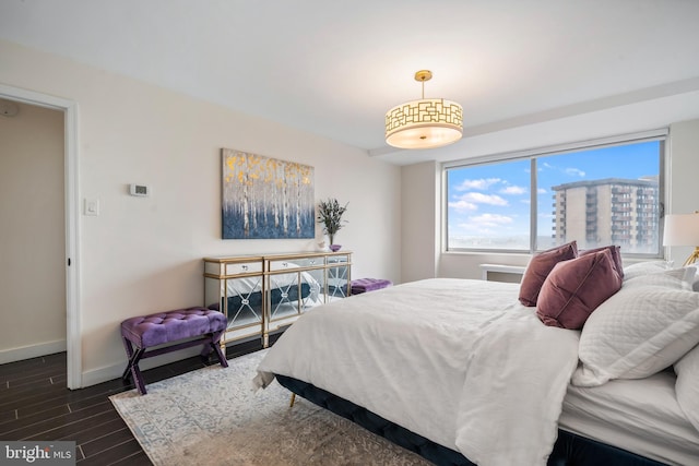 bedroom with baseboards and dark wood-style floors