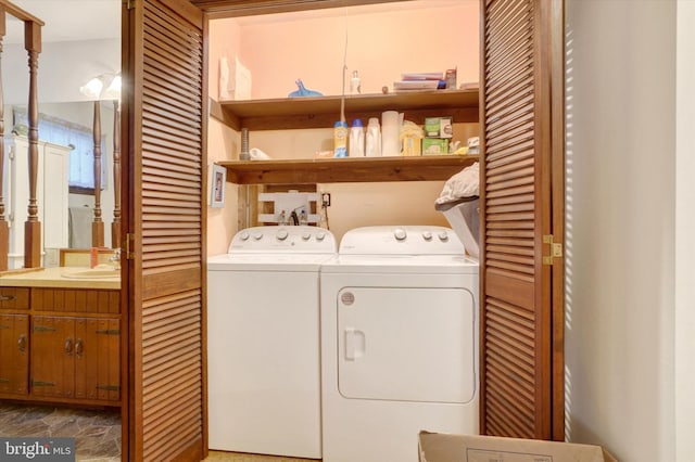 washroom with laundry area, stone finish floor, independent washer and dryer, and a sink