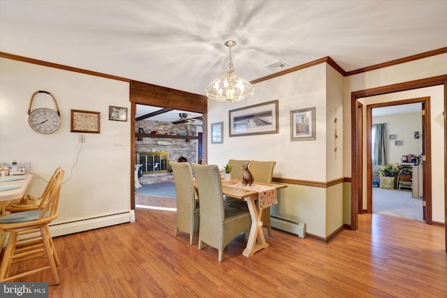 dining room with visible vents, baseboard heating, and light wood finished floors