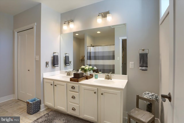 full bathroom featuring a sink, baseboards, a shower with shower curtain, and double vanity