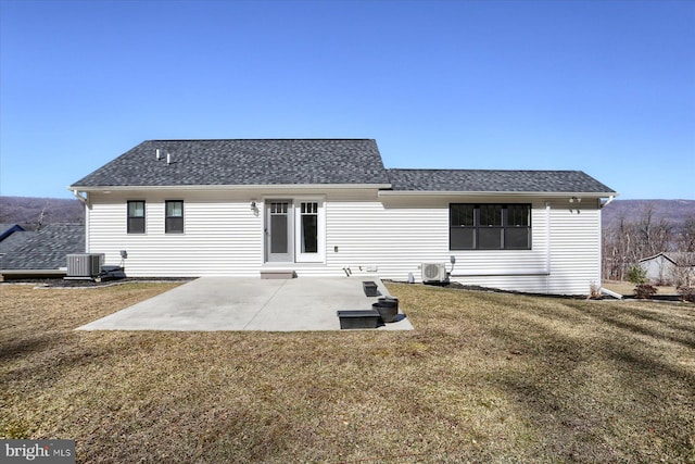 back of property with a patio area, central air condition unit, a lawn, and roof with shingles