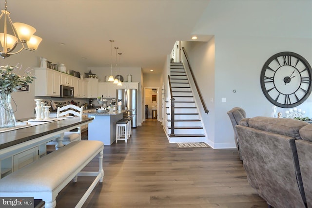 dining area with dark wood-type flooring, recessed lighting, stairway, an inviting chandelier, and baseboards