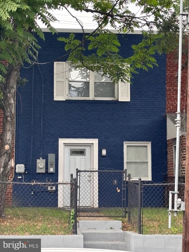 view of front of house featuring a fenced front yard and brick siding