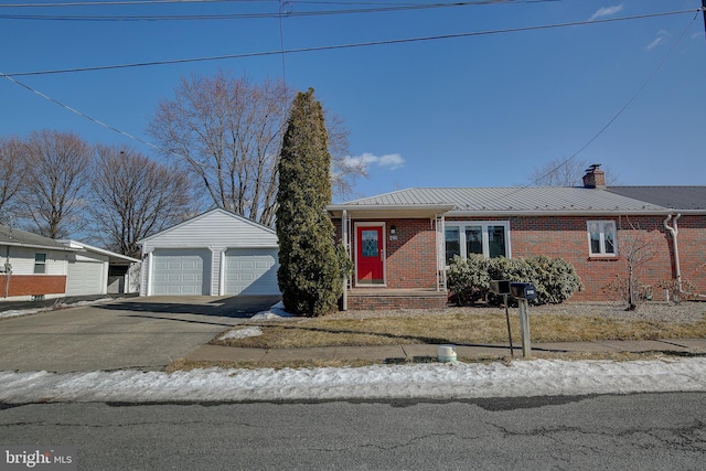 view of front of property with an outdoor structure, a garage, brick siding, and metal roof