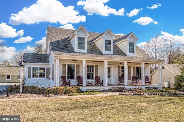 cape cod home featuring a porch, a ceiling fan, a front lawn, and roof with shingles