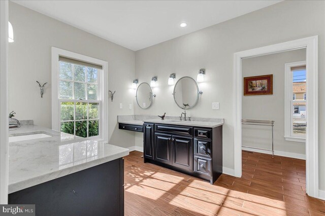 bathroom featuring recessed lighting, baseboards, wood finished floors, and vanity