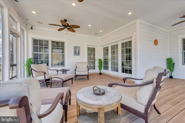 wooden terrace with an outdoor hangout area, french doors, and ceiling fan