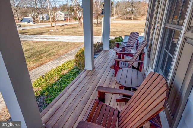 wooden deck featuring a lawn and a porch